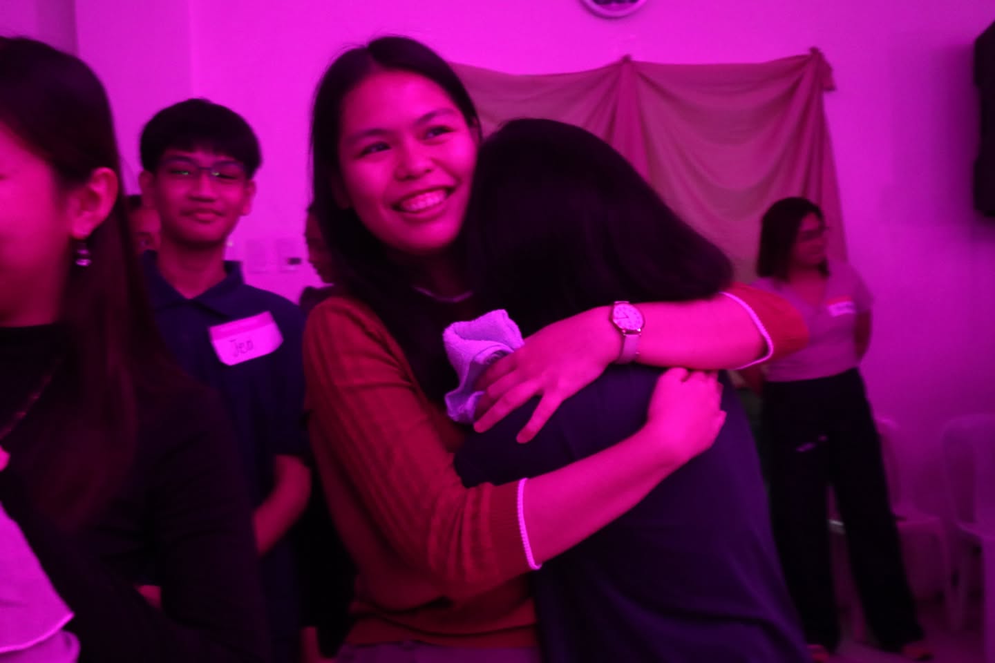 Two friends sharing a hug during Ignite 2025
